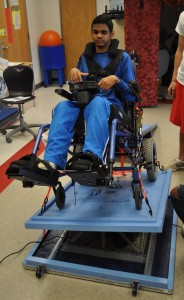 Figure 2: Client enjoying a ride on the Wheelchair Accessible Motion Simulator, currently tilted to his right and back.