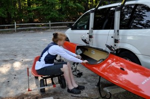 Figure 2b: the client lifting the kayak from the rack in its lowered position, and moving it to the cart for transporting it to the water